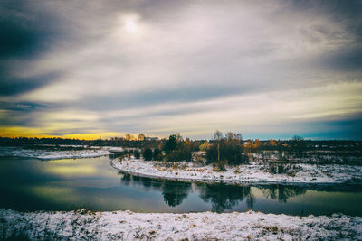 Scenic view of lake against sky at sunset