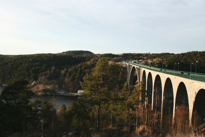 Arch bridge on landscape against sky