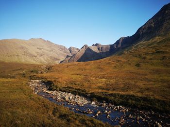 Scenic view of landscape and mountains against clear blue sky