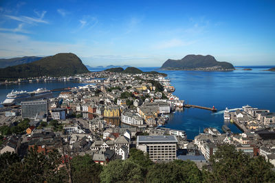 Aerial view of city by sea against sky