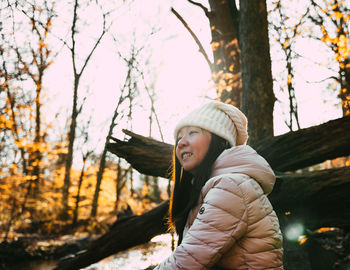 Portrait of young woman standing in forest