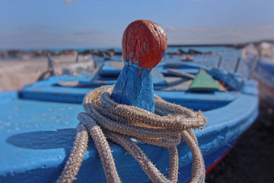 Close-up of rope tied to fishing net on beach