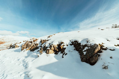 Snow covered landscape against sky