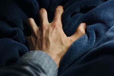 Cropped image of hand on blanket