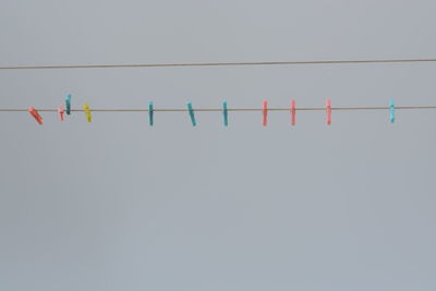 Close-up of clothespins hanging on white background