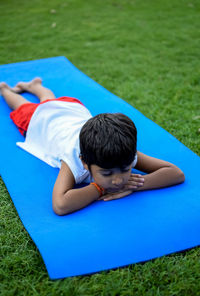 Asian smart kid doing yoga pose in the society park outdoor, children's yoga pose. the little boy