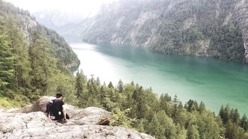Man looking at waterfall against mountain