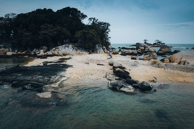 Rocks on beach against sky