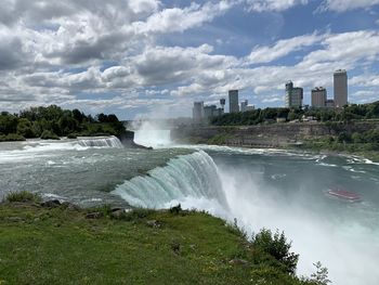 Scenic view of waterfall against sky in city