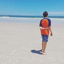 Rear view of a man walking on beach