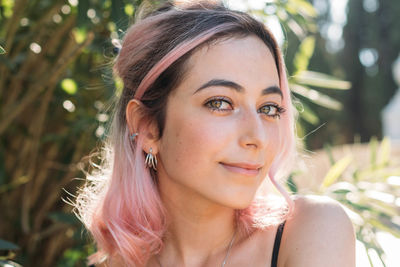 Portrait of beautiful young woman sitting outdoors