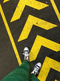 Low section of man standing on road