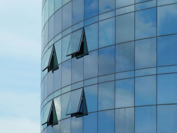 Low angle view of glass building against sky