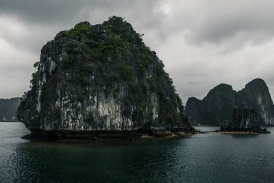 Rock formation in sea against sky