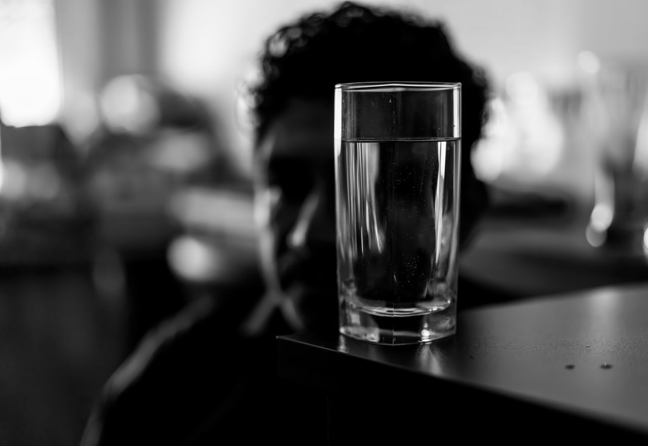 black, glass, drinking glass, drink, black and white, food and drink, household equipment, refreshment, monochrome, indoors, table, monochrome photography, focus on foreground, white, alcohol, adult, one person, close-up, bar, selective focus, lifestyles, shot glass