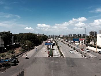 Cars on road in city against sky