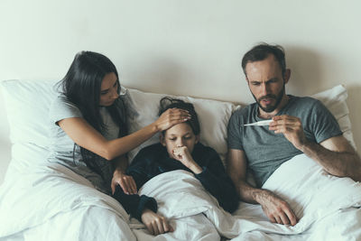 Worried parents taking care of son at home