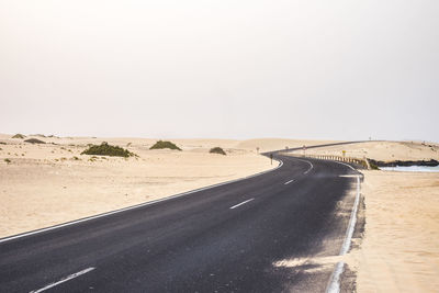 Scenic view of road at beach clear sky