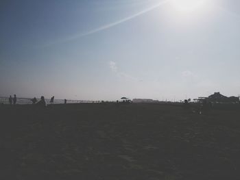 Silhouette people on field against clear sky