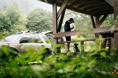 Man and french bulldog dog at picnic by the car in the forest