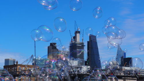 View of bubbles against buildings in city