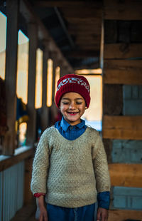 Portrait of smiling boy standing against wall