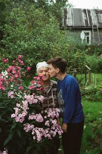 Young woman kissing grandmother on cheek in yard