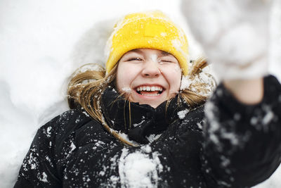 Portrait of smiling young woman standing on snow