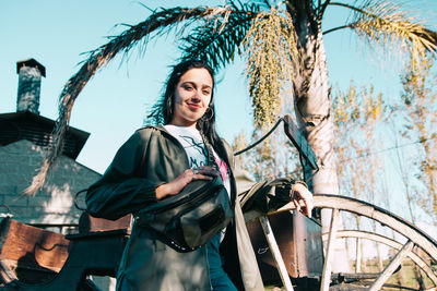 Beautiful young woman standing against retro styled house