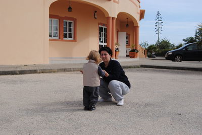 Full length of mother and daughter playing outside house