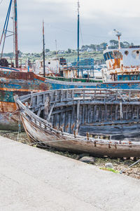 Boats moored at harbor against sky