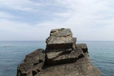 Scenic view of rock formation in sea against sky