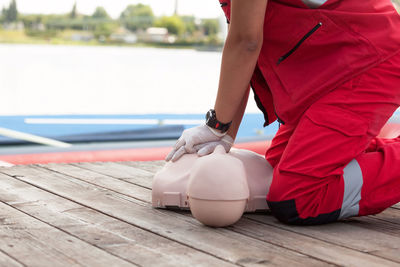 Midsection of man with cpr dummy during training