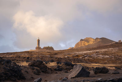 Rock formations on landscape against cloudy sky