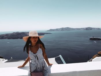 Woman standing by sea against sky