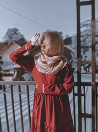 Woman shielding eyes while standing outdoors