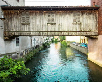 Bridge over river amidst buildings against sky