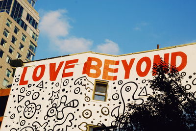 Low angle view of text on building against sky