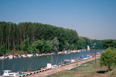 Boats sailing in river against clear blue sky