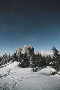 Snow covered landscape against clear sky at night