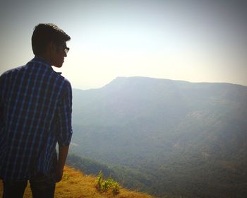 Man standing on mountain against sky