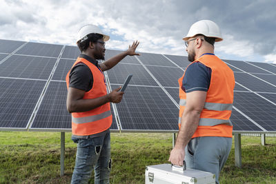 Multiracial colleagues discussing at solar station