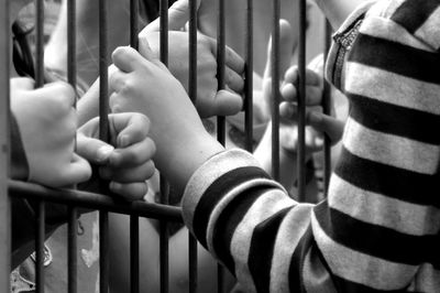 Cropped hands holding metal gate