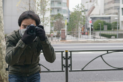 Young woman photographing with camera