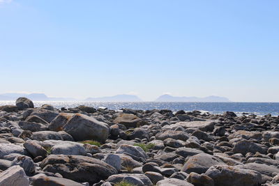 Rocks on beach against clear sky