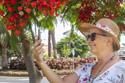 Smiling senior woman talking on video call at park