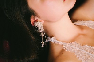 Midsection of young woman wearing earring