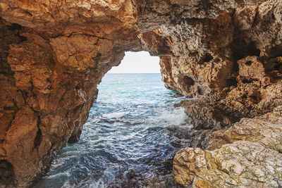 Scenic view of sea seen through cave