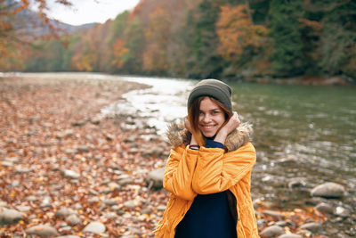 Portrait of smiling young woman standing during autumn