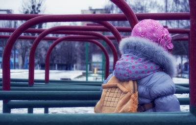 Rear view of girl wearing fur coat at park